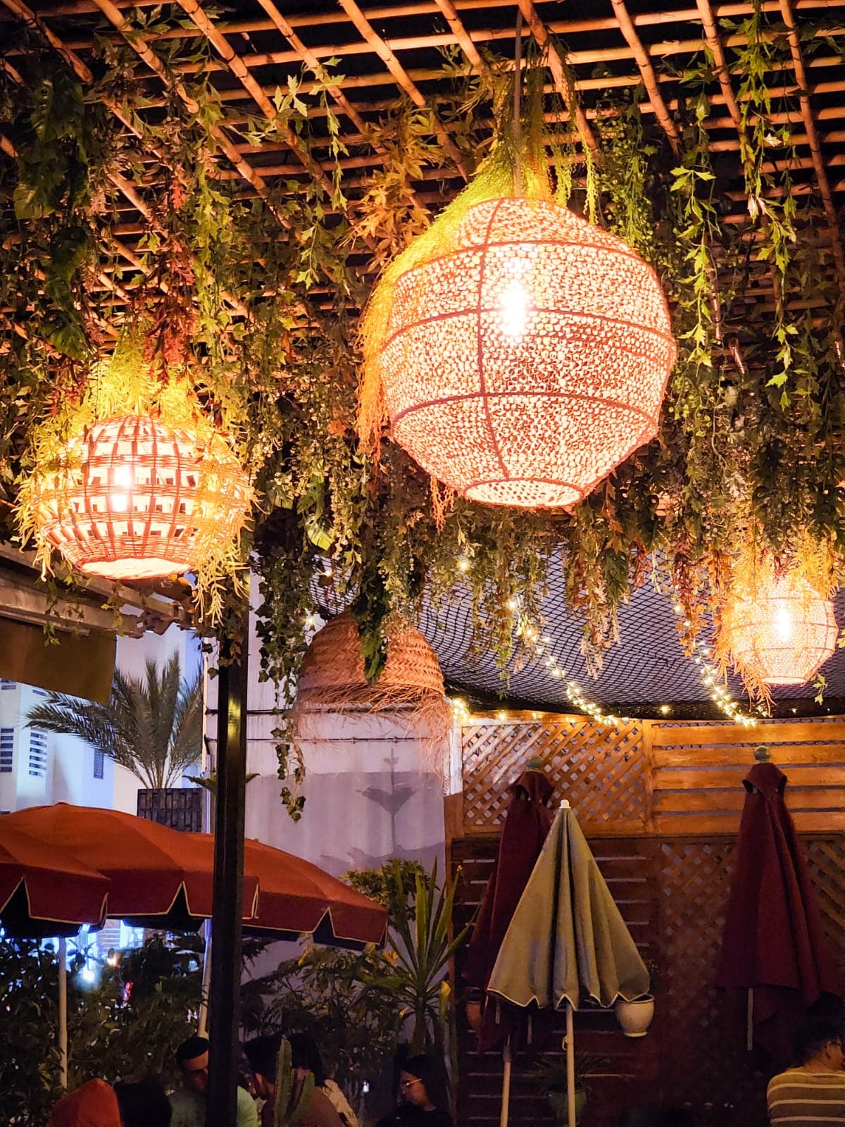 La terrasse en soirée, sous les lampes en rotin